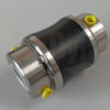 The picture shows a joint for Bornemann EH 1024 progressing cavity pumps. It is made of metal and is set diagonally against a neutral white background. In the middle you can see the black joint sleeve. The openings for the hinge pins are closed off on both sides by means of yellow caps. On the left you can see the large opening for the rotor or the coupling rod. It is also sealed with a white cap.