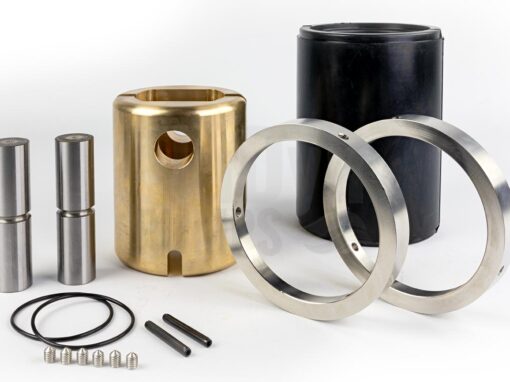 Das Bild zeigt die Einzelteile eines Gelenks für Bornemann EH 6300.1 Exzenterschneckenpumpen / Monopumpen. Links hinten sieht man stehend zwei Gelenkbolzen aus Metall, rechts daneben eine messingfarbene Gelenkbuchse, eine schwarze Gelenkmanschette aus einer Art Gummi und davor zwei Gelenkschutzhülsen aus Metall. Im Vordergrund liegen ein paar Kleinteile: zwei O-Ringe, zwei Zyko-Hülsen und sechs spitze Gewindestifte.