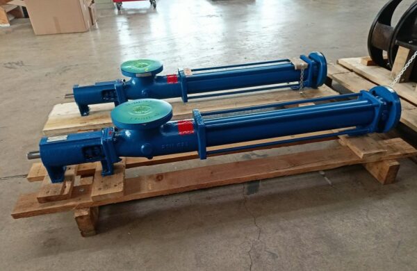 Two blue mono pumps without motors screwed together on a wooden pallet for shipment