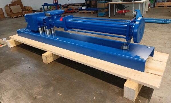 A large blue Fludyn BE2H 1024 progressive cavity pump without motor, with spacer rings, bolted to a base plate and aligned. The whole thing is mounted on a wooden pallet ready for shipment.