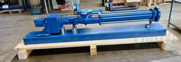 Eine blaue Fludyn BE4H 1024 Exzenterschneckenpumpe / Monopumpe, ohne Motor mit Grundplatte quer auf einer Holzpalette verschraubt