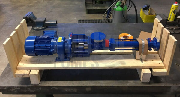 A blue Fludyn BEL 164 progressing cavity pump / mono pump, including motor, bolted crosswise on a wooden pallet